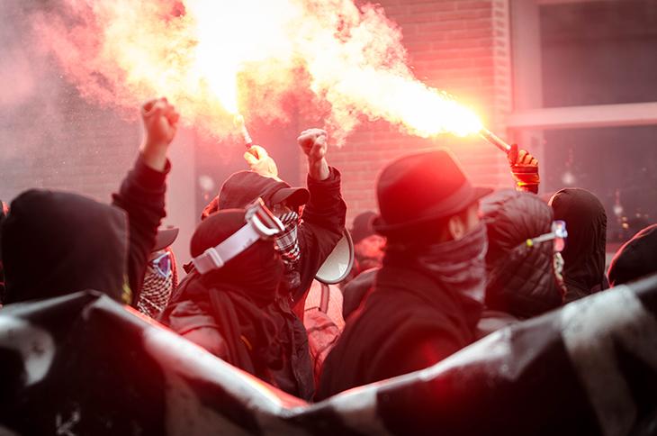 Des antifas masqués allument des fumigènes