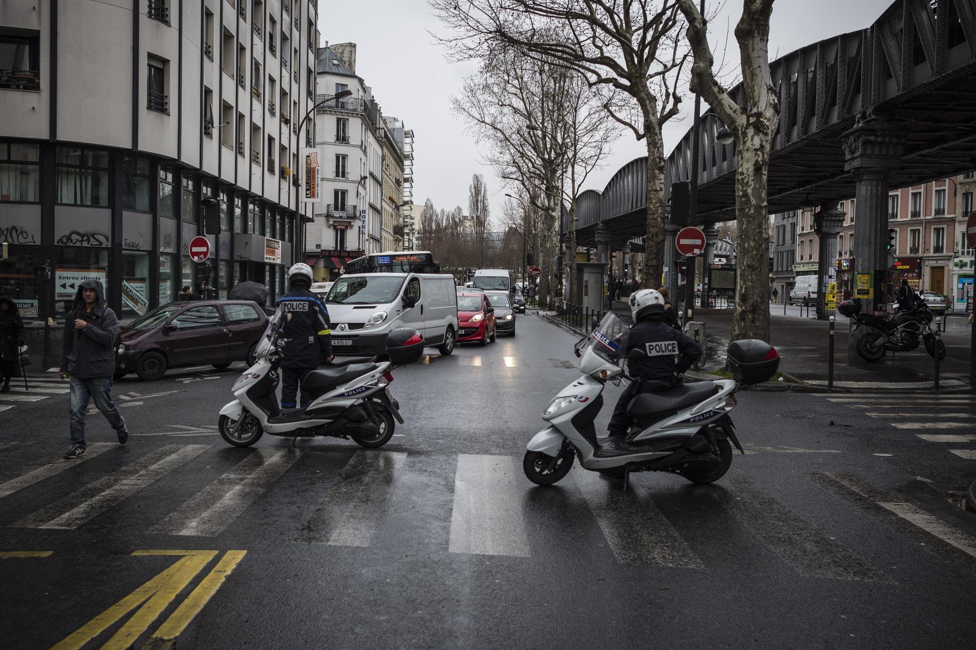 Deux policiers en scooters barrent une rue du 18e.