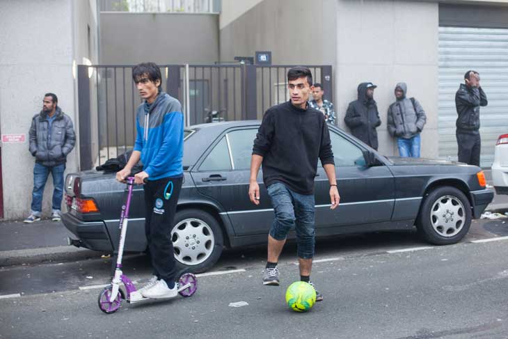 Des réfugiés jouent dans la rue en attendant l'arrivée des bu