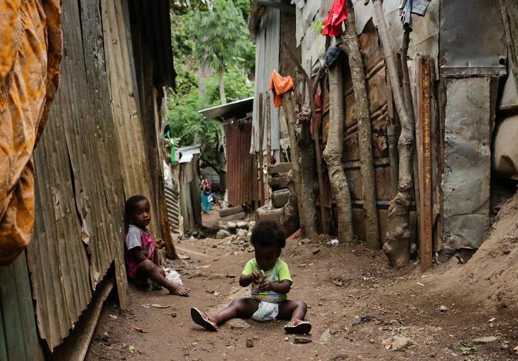 Des enfants seuls traînent dans les ruelles du bidonville