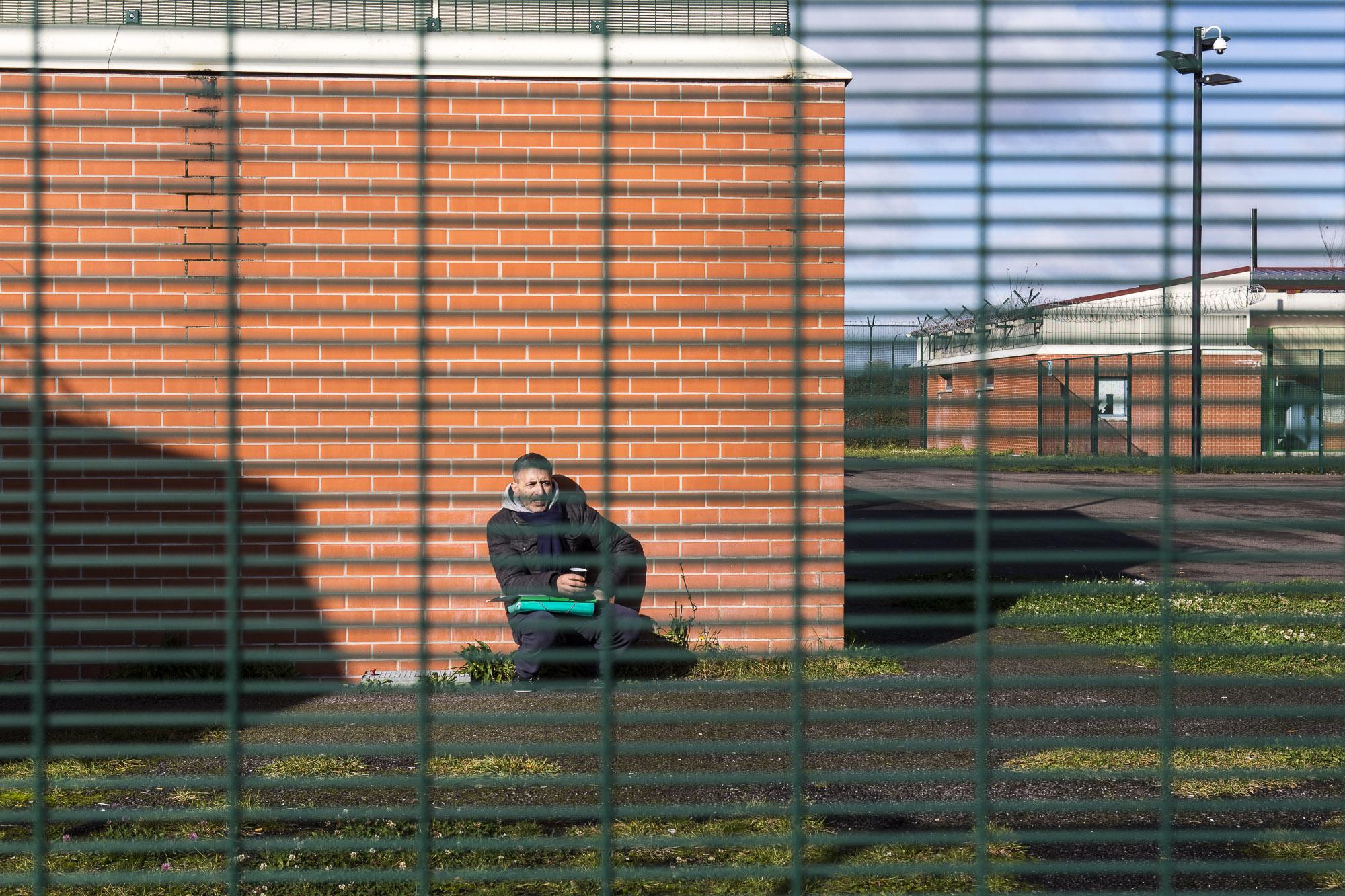 À l'arrière de l'un des bâtiments du CRA, un homme boit le thé