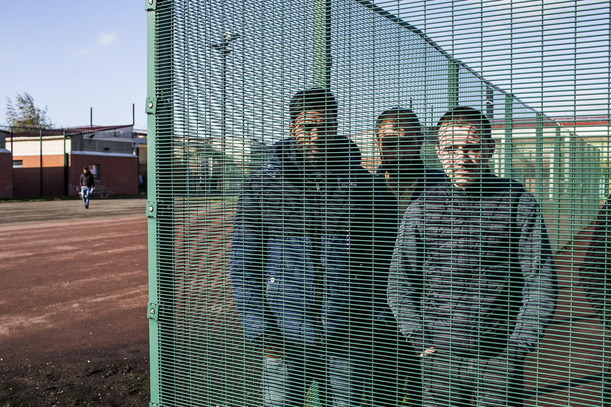 Dans la cour du CRA, des retenus nous interpellent derrière les grilles