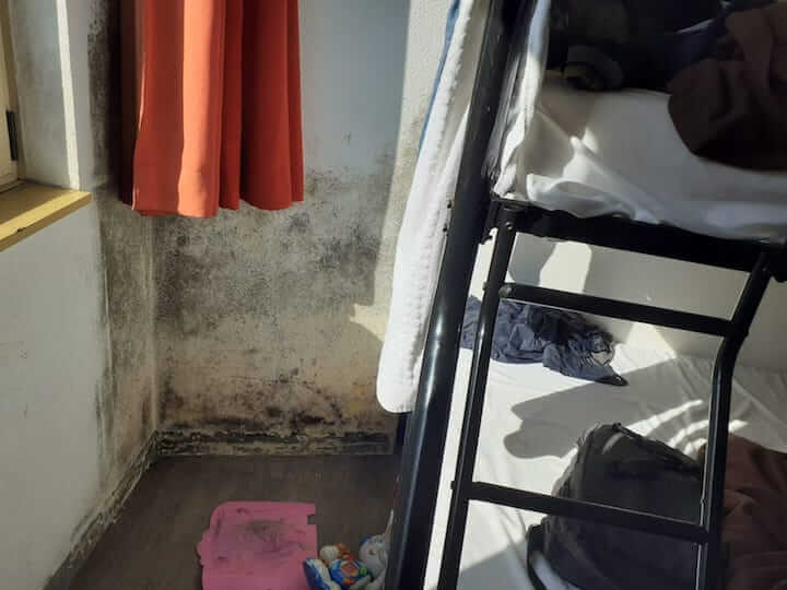 La chambre de l'hôtel social de Souleymane et sa famille est marquée par la moisissure et la promiscuité.