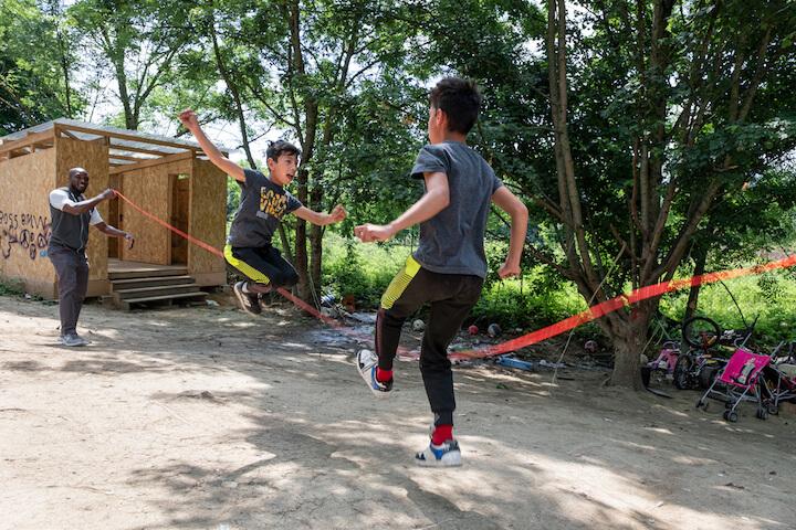 Gabriel et son frère jumeau jouent avec une longue corde et sautent à trois avec un voisin