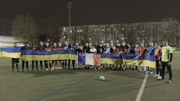 À la fin du match, Igor Karumov fait poser le FC Bandera avec ses adversaires du soir, autour d'un drapeau ukrainien.