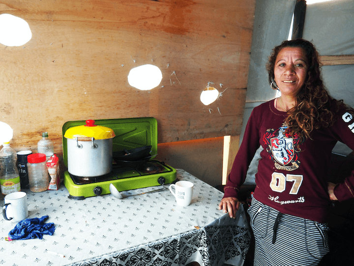 Roxana et son fils vivent dans une tente installée sous un abri en bois.