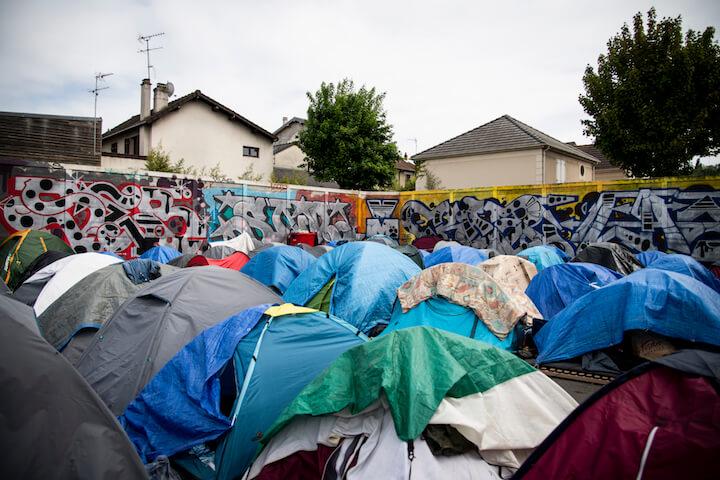 À Pantin, plus de 200 personnes patientent sur le terrain vague désormais plein à craquer du Cheval Noir, ceinturé par trois épais murs de béton.