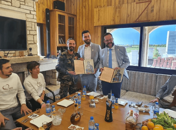 Benjamin Blanchard (à droite), remet une lettre d’amitié à Nabel Al-Abdullah, chef de guerre accusé de crimes de guerre (à gauche, en treillis), début mai dernier en Syrie