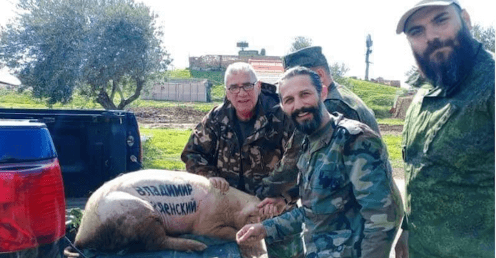 Les chefs de milice Simon Al-Wakil et Nabel Al-Abdullah, partenaires de SOS Chrétiens d’Orient en Syrie, posent avec un cochon où a été inscrit le nom de Volodomyr Zelensky, en mars dernier