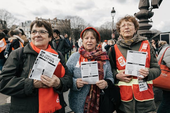 Devant Agathe, un petit auditoire reprend les paroles, livret à la main. Parmi eux, Clothilde, 82 ans et deux amies : « Nous on est de la CGT retraités », affirme-t-elle, « On montre qu’on est là ! 