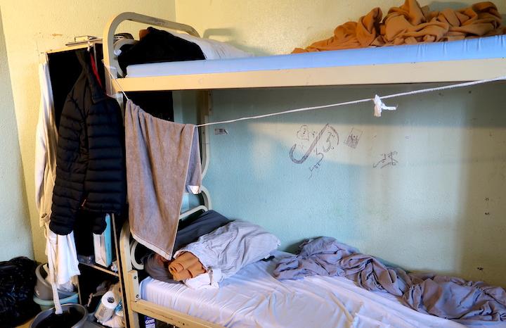 En cellule, pas de douche : un lit à étage d’un côté et un une place de l’autre, une télé posée sur un frigo et des toilettes sans porte
