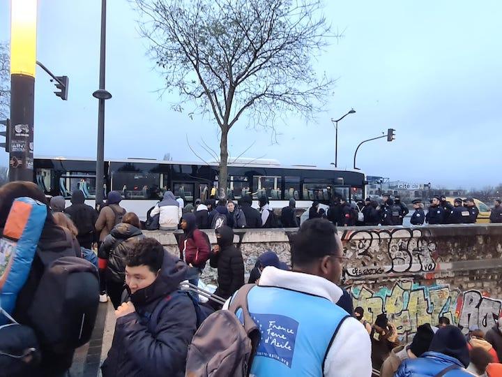 Sous le regard stoïque des forces de l’ordre, des cars emmènent les volontaires, quel que soit leur statut administratif, dans l’un des dix sas d’accueil temporaire régionaux ouverts en province.