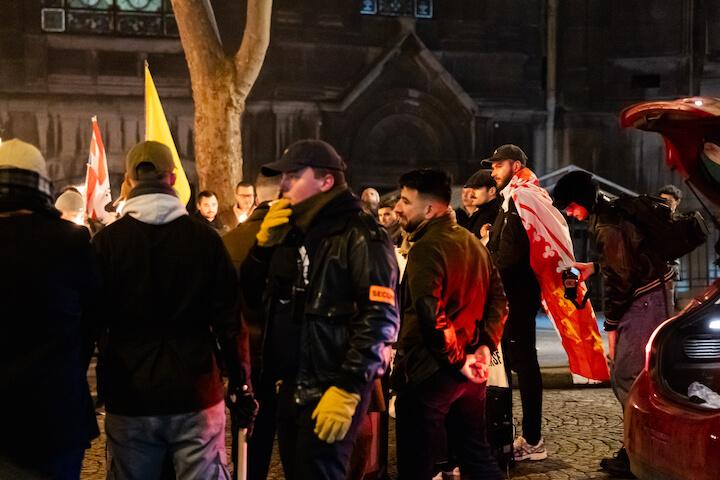 Maxence, militant de l’Action française, vêtu d'un blouson en cuir, d'une casquette Lyle and Scott et d'un brassard sécurité