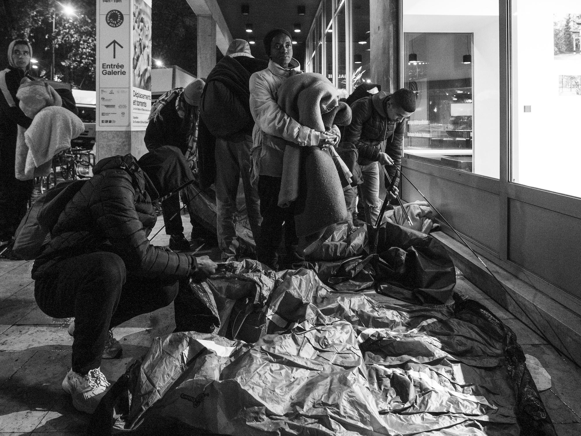 Des dizaines d'exilés installent, comme chaque soir, leur campement sous les arches de la Cité internationale des Arts, au niveau de la galerie marchande