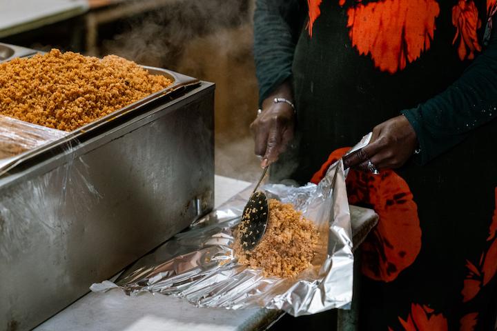Nana sert le tieb dans une feuille d'aluminium pour garder le riz au chaud