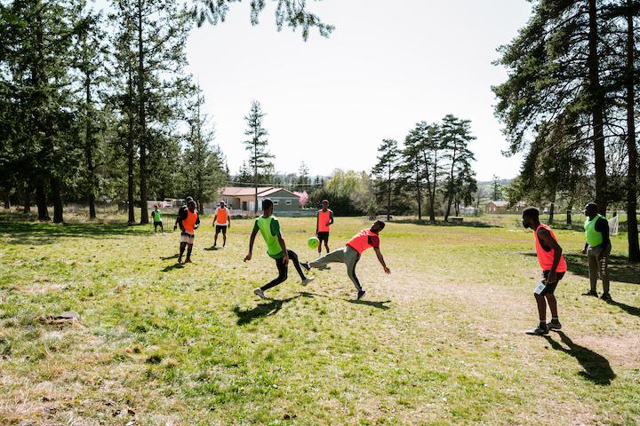 Des hommes du Cada jouent au foot dans le jardin.